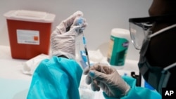 Seorang petugas kesehatan mempersiapkan vaksinasi COVID-19 Pfizer di Museum Sejarah Alam Amerika di New York, 22 Juli 2021. 
