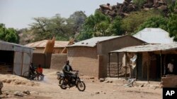 Un homme roule en moto sur une route du village Chibok, Nigeria, 19 mai 2014.