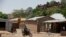FILE -  An unidentified man rides a motorbike past houses in Chibok, Nigeria, May 19, 2014. 