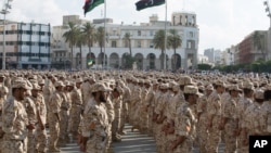 FILE - Military units under the Tripoli government stand in formation during a celebration of the 75th anniversary of the establishment of the Libyan Army in Martyrs Square, Tripoli, Aug. 13, 2015.