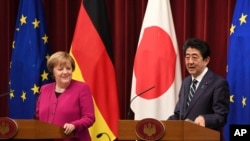 Kanselir Jerman Angela Merkel (kiri) dan Perdana Menteri Jepang Shinzo Abe (kanan) menghadiri konferensi pers bersama setelah pertemuan puncak mereka di kediaman resmi Abe di Tokyo, Senin, 4 Februari 2019. 