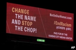 FILE - A billboard calling for a name change and an end to the Kansas City Chiefs "tomahawk chop" stands along Interstate 70 in Kansas City, Missouri, on Feb. 3, 2021.