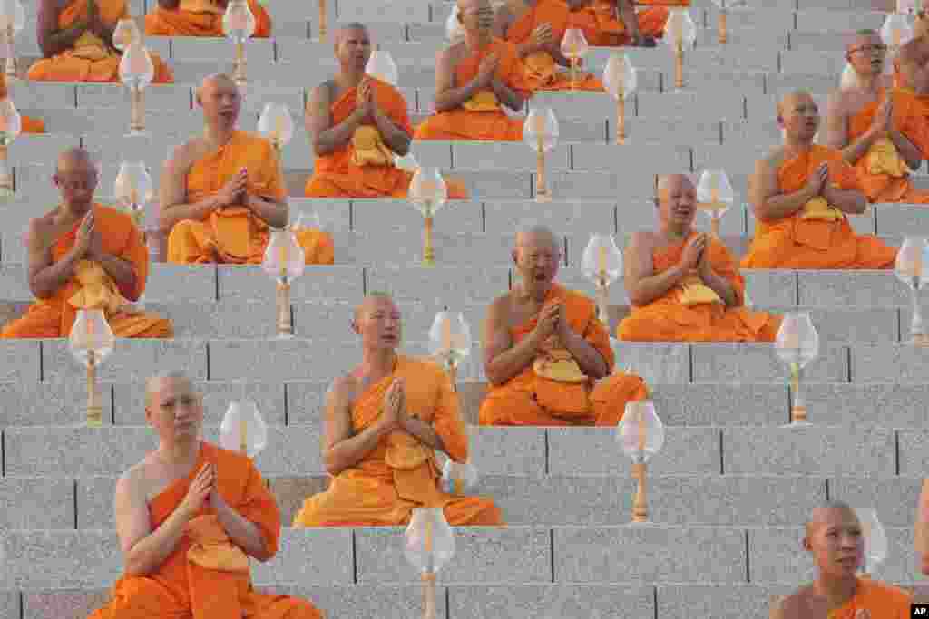 Thai Buddhist monks pray as they gather at Wat Dhammakaya temple to participate in Makha Bucha Day ceremonies in Pathum Thani, Thailand.