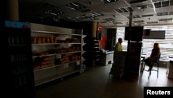 People chat at a supermarket as they wait for the power to return during a blackout in Maracaibo, Venezuela, March 30, 2019. 