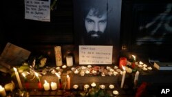A photo of missing activist Santiago Maldonado is surrounded by candles and a message that reads in Spanish: "Santiago, your solidarity has made you the son of all," at a makeshift memorial outside the morgue, in Buenos Aires, Argentina, Oct. 20, 2017. 
