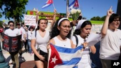 Demonstrators walk down Eighth Street in the Little Havana neighborhood of Miami, July 18, 2021.