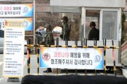 South Korean soldiers wearing masks to prevent contacting the coronavirus stand guard at a checkpoint of a military base in Daegu, South Korea, Feb. 26, 2020.