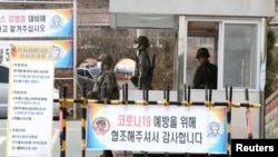 Tentara Korea Selatan mengenakan masker saat berjaga di pos pemeriksaan pangkalan militer di Daegu, Korea Selatan, di tengah pandemi COVID-19, 26 Februari 2020. (Yonhap via REUTERS).