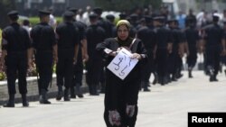 Polisi Mesir melakukan penjagaan di Sinai sementara seorang wanita melakukan unjuk rasa (foto; dok). Seorang tahanan AS di Sinai ditemukan tewas di selnya. 