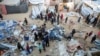 Palestinians inspect the damage at a tent camp sheltering displaced people, following an Israeli strike in Khan Younis on December 18, 2024.