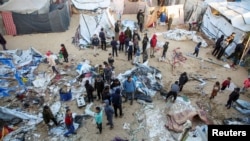 Palestinians inspect the damage at a tent camp sheltering displaced people, following an Israeli strike in Khan Younis on December 18, 2024.