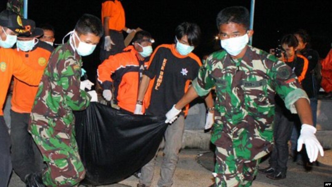 Nhân viên cứu hộ Indonesia khiêng xác một nạn nhân trong vụ sập cầu Kutai Kartanegara ở Tenggarong, ngày 29/11/2011