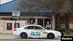 FILE - Military police guard the visitors center at the entrance to Fort Hood, Texas. 