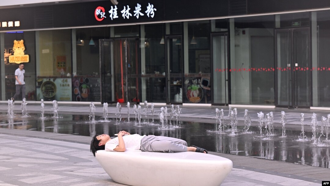 一名男子在北京一家商場的噴泉旁睡覺。 （2024年7月18日）