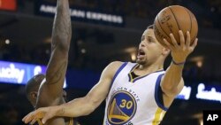 Le pivot de Warriors du Golden State, Stephen Curry (30), tente un shoot en face de LeBron James des Cavaliers Cleveland au cours de la première mi-temps du deuxième match de la finale NBA de basket-ball, à Oakland, en Californie, 5 juin, 2016. (AP Photo / Marcio Jose Sanchez)