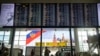 Passengers walk past a departure board at Sheremetyevo international airport in Moscow, Russia, July 8, 2019. 