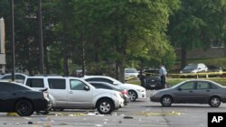 Sejumlah petugas dari tim investigasi kepolisian berada di lokasi kejadian insiden penembakan di sebuah lapangan parkir dari sebuah mal di Willowbrook, Illinois, pada 18 Juni 2023. (Foto: AP/Matt Marton)