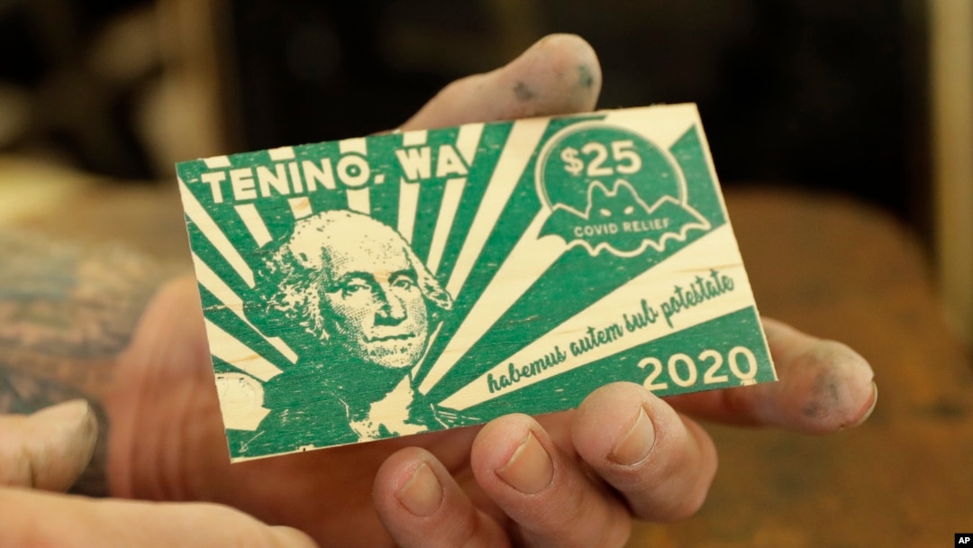 Loren Ackerman menunjukkan uang kayu yang dicetak menggunakan mesin cetak 1890an di Tenino, Washington, 21 Mei 2020. (Foto: AP)