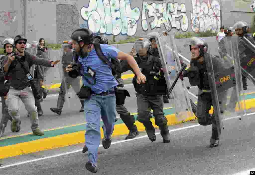 Reuters photojournalist Marco Bello runs as Venezuelan National Guard soldiers chase him during a protest outside the Supreme Court in Caracas. Security forces violently repressed small protests that broke out in the city after the government-stacked Supreme Court gutted congress of its last vestiges of power, drawing widespread condemnation from foreign governments.