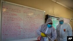 A disinfection team disinfects a classroom at Ivory Park Secondary School east of Johannesburg, South Africa, May 28, 2020, ahead of the June 1, 2020, reopening of Grade 7 and 12 learners to school.