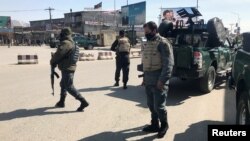 Policemen keep watch near the side of an attack in Kabul, Afghanistan, March 7, 2019.