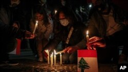 Lebanese residents in Chile hold a vigil for the victims of the deadly explosion which devastated the port and large parts of Beirut, in front of the Lebanon Embassy in Santiago, Chile, Aug. 10, 2020.