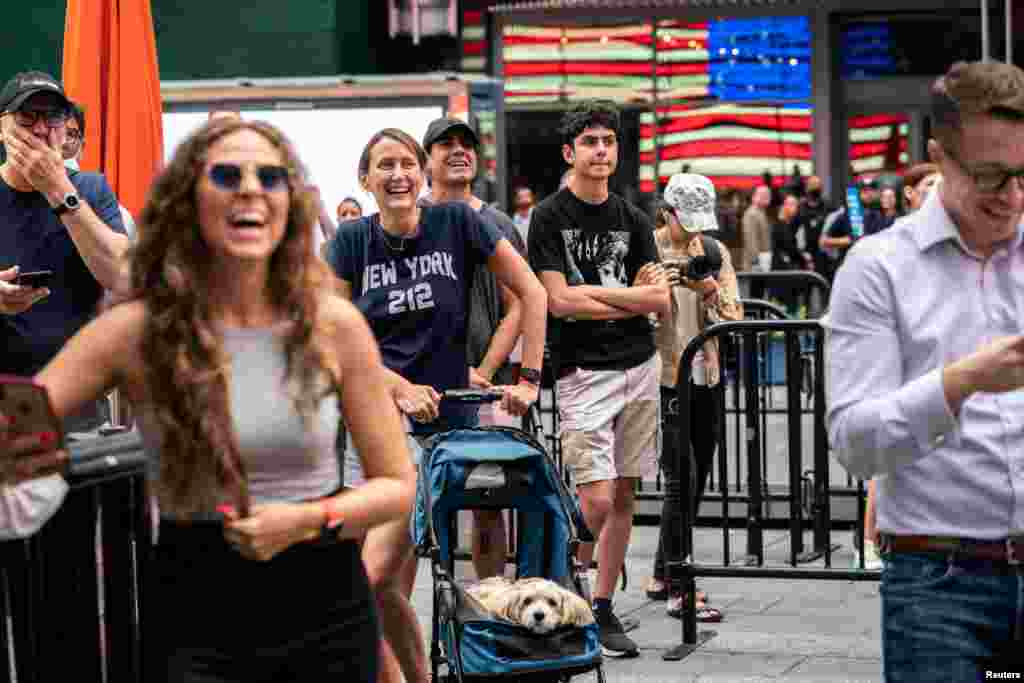 People watch the launch of billionaire American businessman Jeff Bezos and his three crew-mates on Blue Origin&#39;s inaugural flight to the edge of space, on a screen in Times Square in New York City.