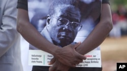 Un partisan du président zimbabwéen Robert Mugabe tient le portrait de celui-ci lors des célébrations du 93e anniversaire de celui-ci à Matopos, dans la banlieue de Bulawayo, 25 février 2017. 