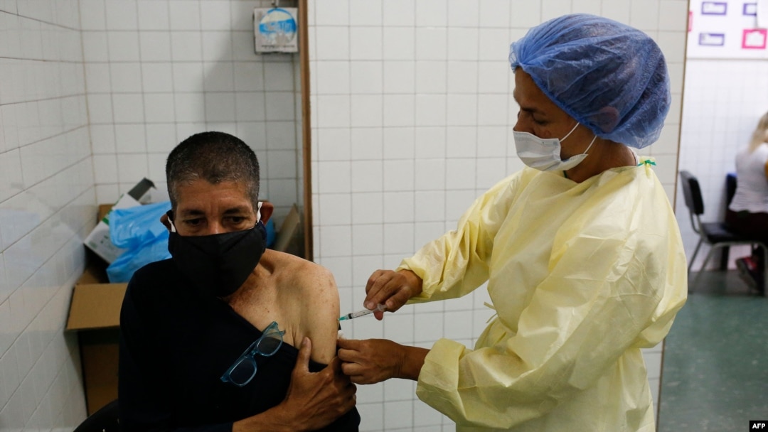 Un trabajador de salud administra una dosis de la vacuna Sputnik V contra COVID-19 a un anciano en el Hospital Victorino Santaella en Los Teques, Venezuela, el 9 de abril de 2021, en medio de la pandemia de coronavirus en curso.