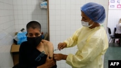 Un trabajador de salud administra una dosis de la vacuna Sputnik V contra COVID-19 a un anciano en el Hospital Victorino Santaella en Los Teques, Venezuela, el 9 de abril de 2021, en medio de la pandemia de coronavirus en curso.