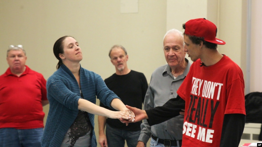 Army veteran Carissa DiPietro takes the hand of Iraq war veteran Mike Mitchels while rehearsing for "Julius Caesar" in Milwaukee. A group of actors is using William Shakespeare’s plays to help veterans with emotional and addiction issues heal, Sept. 27, 2015.