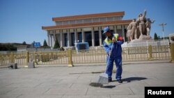 A cleaner sweeps ground in front of the Mausoleum of late Chinese chairman Mao Zedong at Tiananmen Square on the 50th anniversary of the start of the Cultural Revolution in Beijing, China, May 16, 2016.