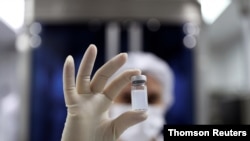 An employee holds a vial of Sinovac Biotech's vaccine against the coronavirus disease (COVID-19) at Butantan biomedical production center in Sao Paulo, Brazil, January 12, 2021.