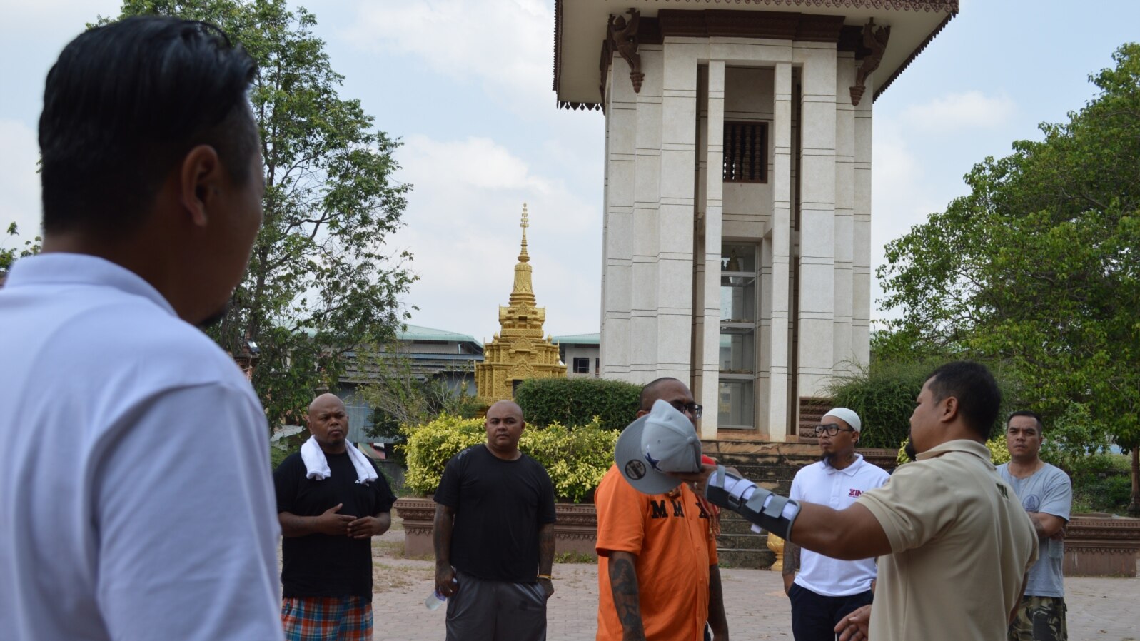 Borby Orn tells new deportees about the killing field site at Wat Snguon Pich pagoda in Cambodia.