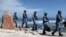 FILE - Soldiers of China's People's Liberation Army (PLA) Navy patrol at Woody Island, in the Paracel Archipelago in the South China Sea, Jan. 29, 2016. 