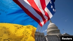 2024年4 月20 日，美国众议院投票通过向乌克兰、以色列和台湾提供 950 亿美元安全援助的议案后，亲乌克兰支持者在国会大厦外高举美国和乌克兰国旗示威。