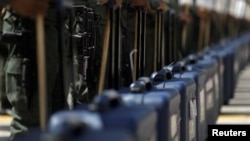 Venezuela's soldiers stand with cases of voting materials during a ceremony ahead of the regional elections which will be held on Oct, 15, in Caracas, Venezuela, Oct. 9, 2017. 