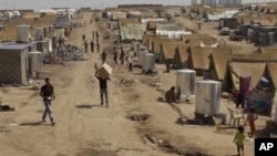 Syrian refugees walk through the Dumez refugee camp in Dahuk, northwest of Baghdad, Iraq, August 13, 2012. 