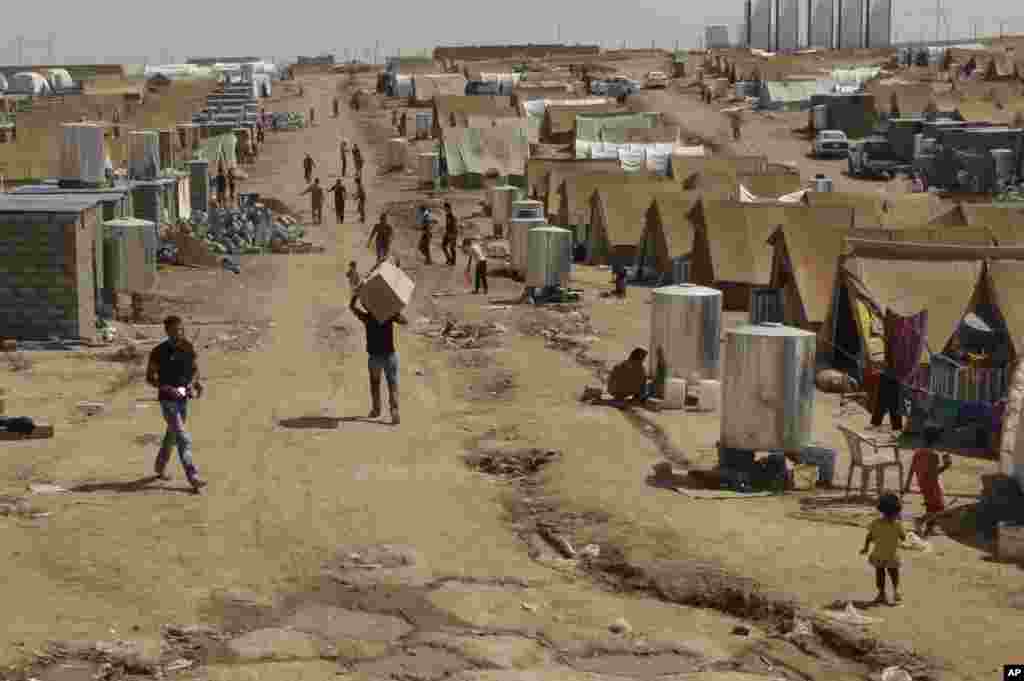 Syrian refugees walk through the Dumez refugee camp in Dahuk, northwest of Baghdad, Iraq, August 13, 2012. 