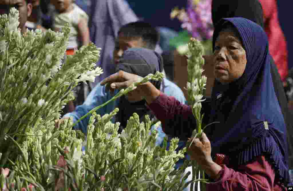 Seorang ibu membeli bunga di sebuah pasar di Jakarta untuk menghiasi rumahnya menjelang Idul Fitri, 4 Juni 2019. (Foto: AP)