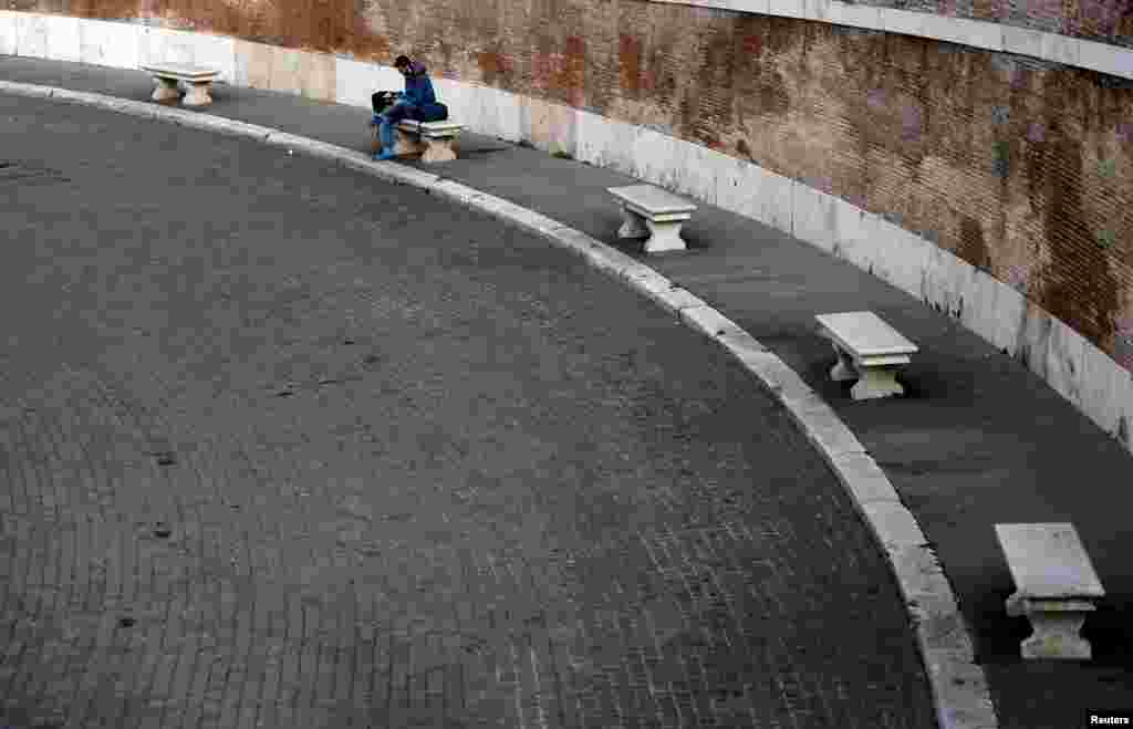 A man sits on a bench at Piazza del Popolo square in Rome, Italy, after the government decree to close schools, cinemas, and urge people to work from home and not stand closer than one meter to each other.