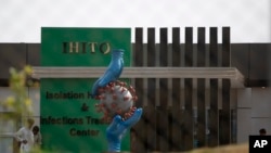 A coronavirus statue stands as workers give final touches to a newly built isolation center in the suburbs of Islamabad, Pakistan, May 12, 2020.