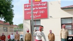 Pemimpin Myanmar Aung San Suu Kyi mengibarkan bendera Partai Liga Nasional untuk Demokrasi dalam sebuah upacara untuk menandai hari pertama kampanye pemilu di markas sementara partai di Naypyitaw, Myanmar pada Selasa, 8 September 2020. (Foto: AP)