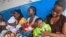 FILE - In this photo taken Nov. 3, 2014,  mothers wait inline for their children to be vaccinated by heath workers at the Pipeline Community Health Center, situated on the outskirts of  Monrovia, Liberia.  