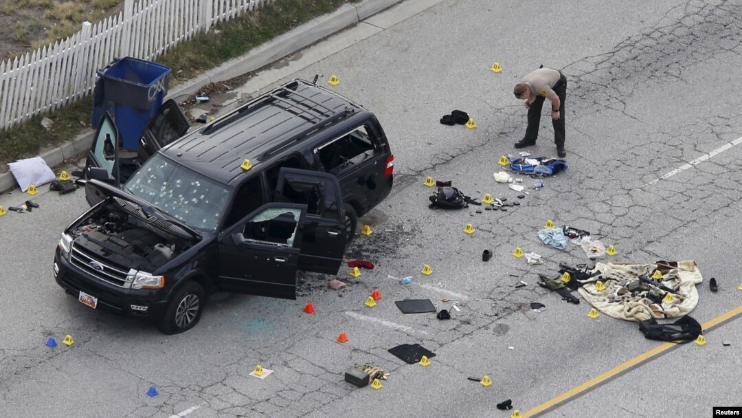 A law enforcement officer looks over the evidence near the remains of a SUV involved in the Wednesdays attack is shown in San Bernardino, California, Dec. 3, 2015. 