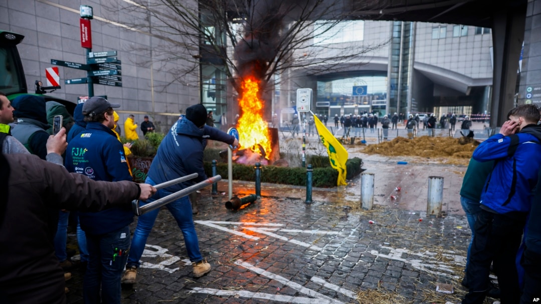 Para petani membakar sampah dan ban saat menggelar demonstrasi di luar Parlemen Eropa di tengah berlangsungnya KTT Uni Eropa di Brussels, Kamis, 1 Februari 2024. (Foto: AP)