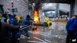 Farmers burn garbage and tires during a protest outside the European Parliament as European leaders meet for an EU summit in Brussels, Feb. 1, 2024.