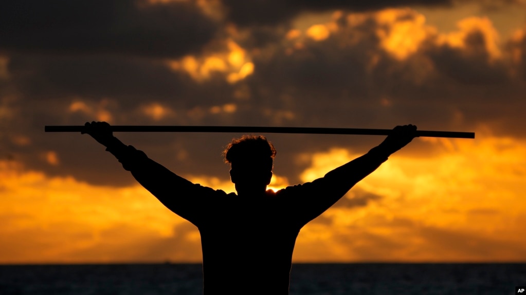 FILE - A beach goer exercises as the sun rises above the Atlantic Ocean, Feb. 1, 2023, in Surfside, Fla. (AP Photo/Wilfredo Lee, File)