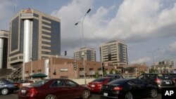 FILE- In this Tuesday, May. 26, 2015 file photo, cars queue in front of the Nigerian National Petroleum Corporation headquarters to buy fuel in Abuja, Nigeria. 