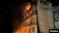 Smoke billows from a building heavily damaged by a Russian drone strikes, amid Russia's attack on Ukraine, in the town of Rzhyshchiv, in Kyiv region, Ukraine March 22, 2023.